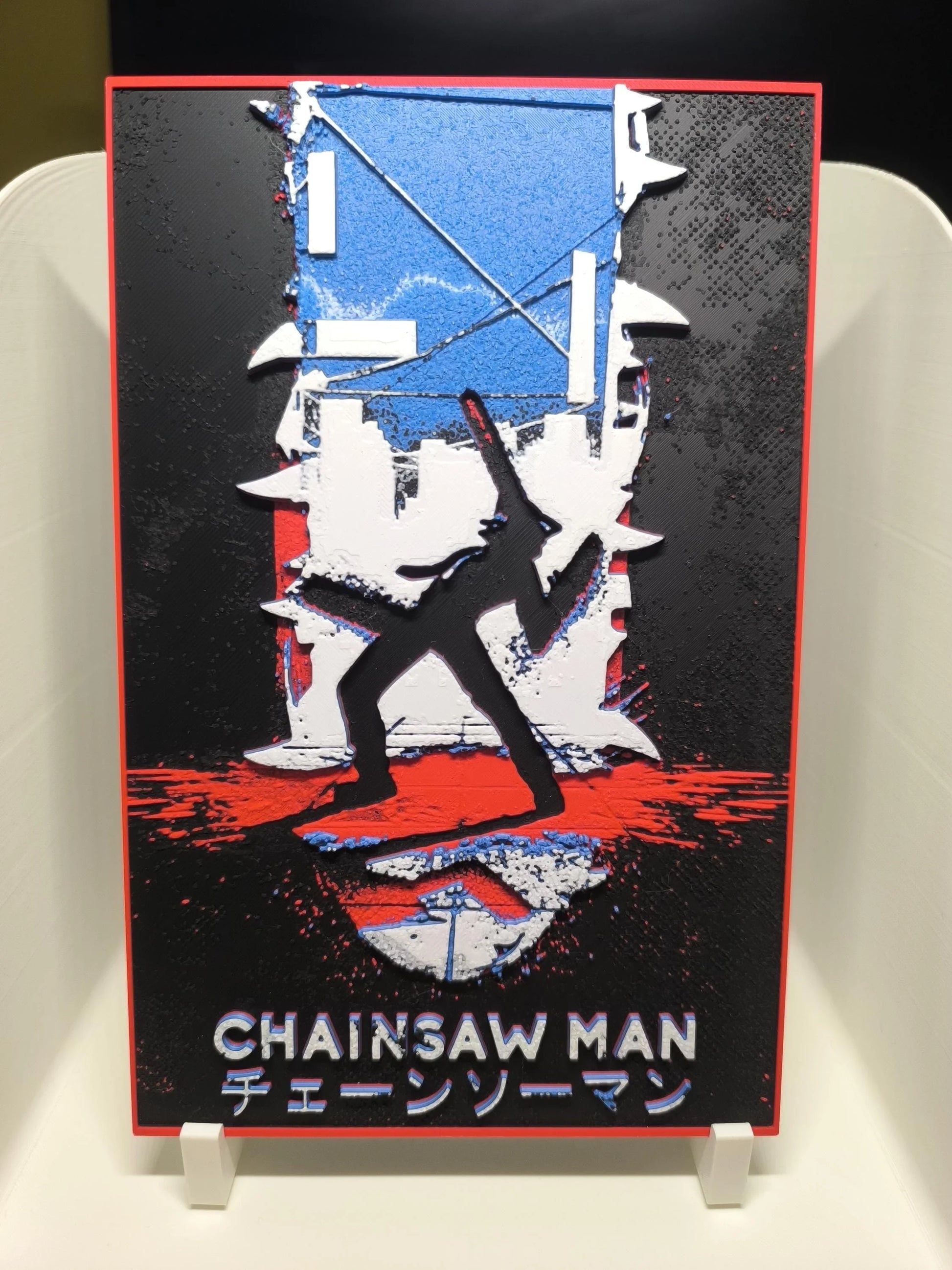 Affiche artistique Chainsaw Man avec silhouette noire, arrière-plan bleu, rouge, blanc, typographie anglaise et japonaise