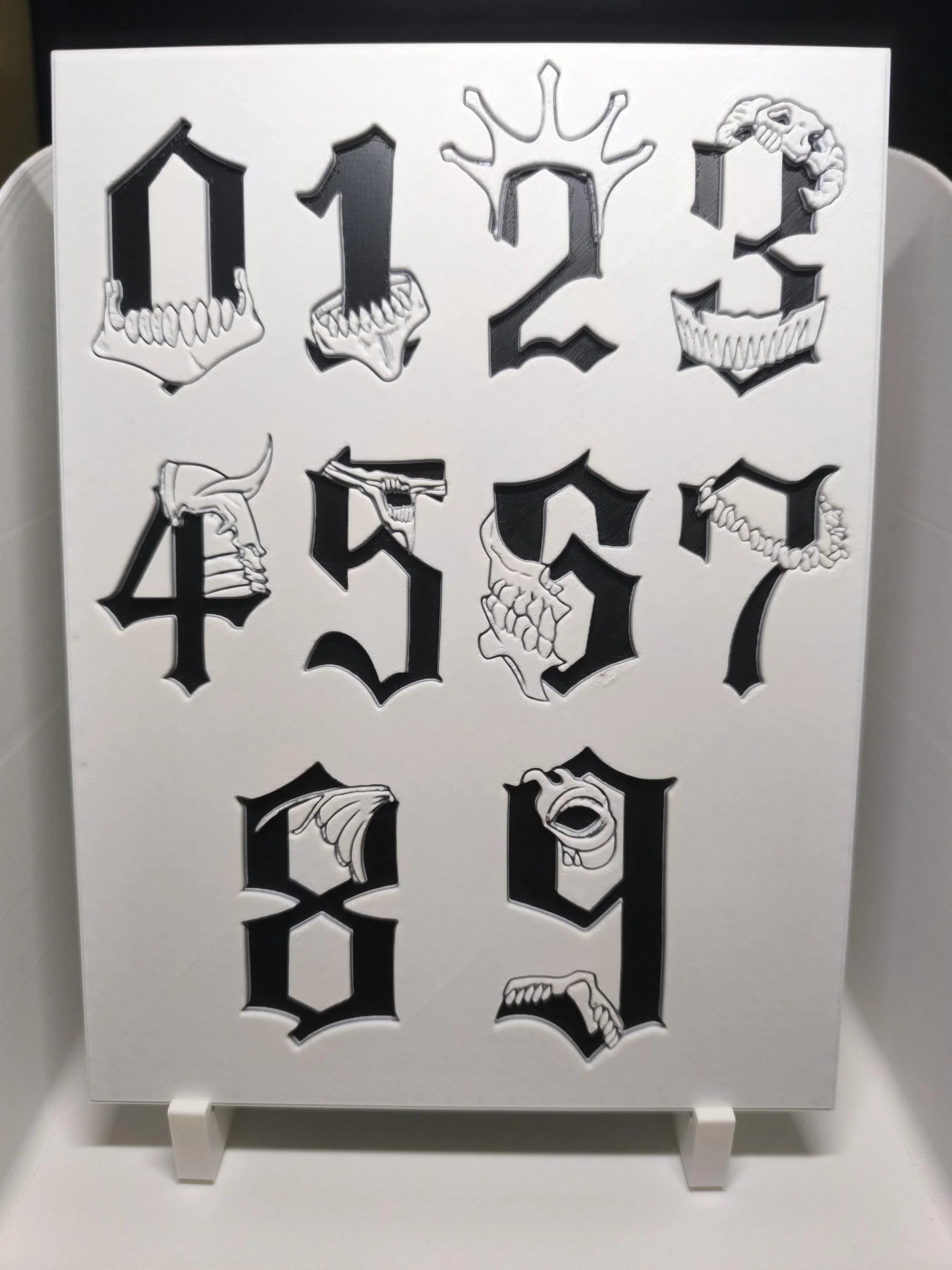 Chiffres gothiques noirs de 0 à 9 avec motifs de crânes et dents blancs en relief
