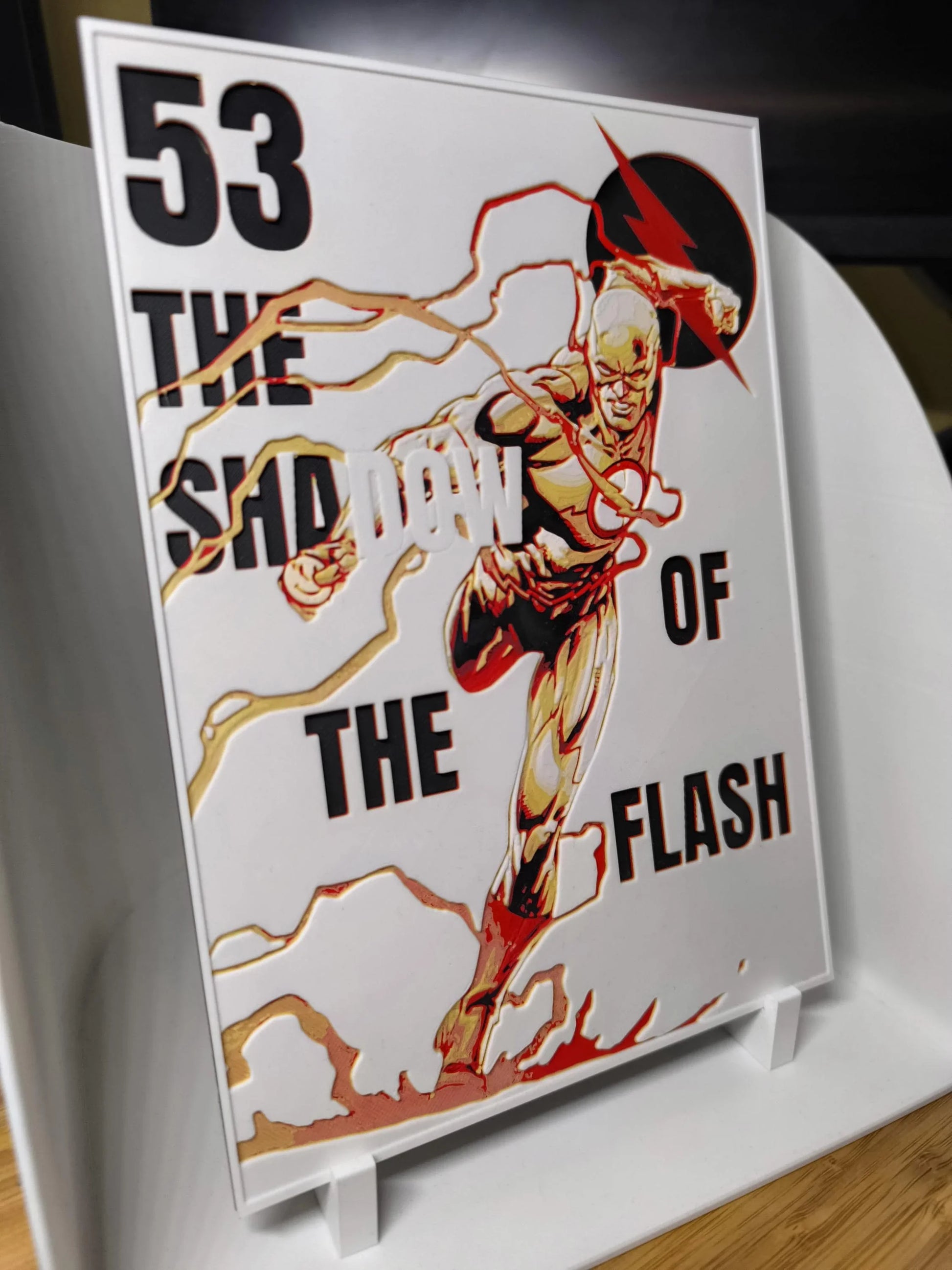 Plaque artistique montrant The Flash en pleine course, éclair doré et rouge, texte noir