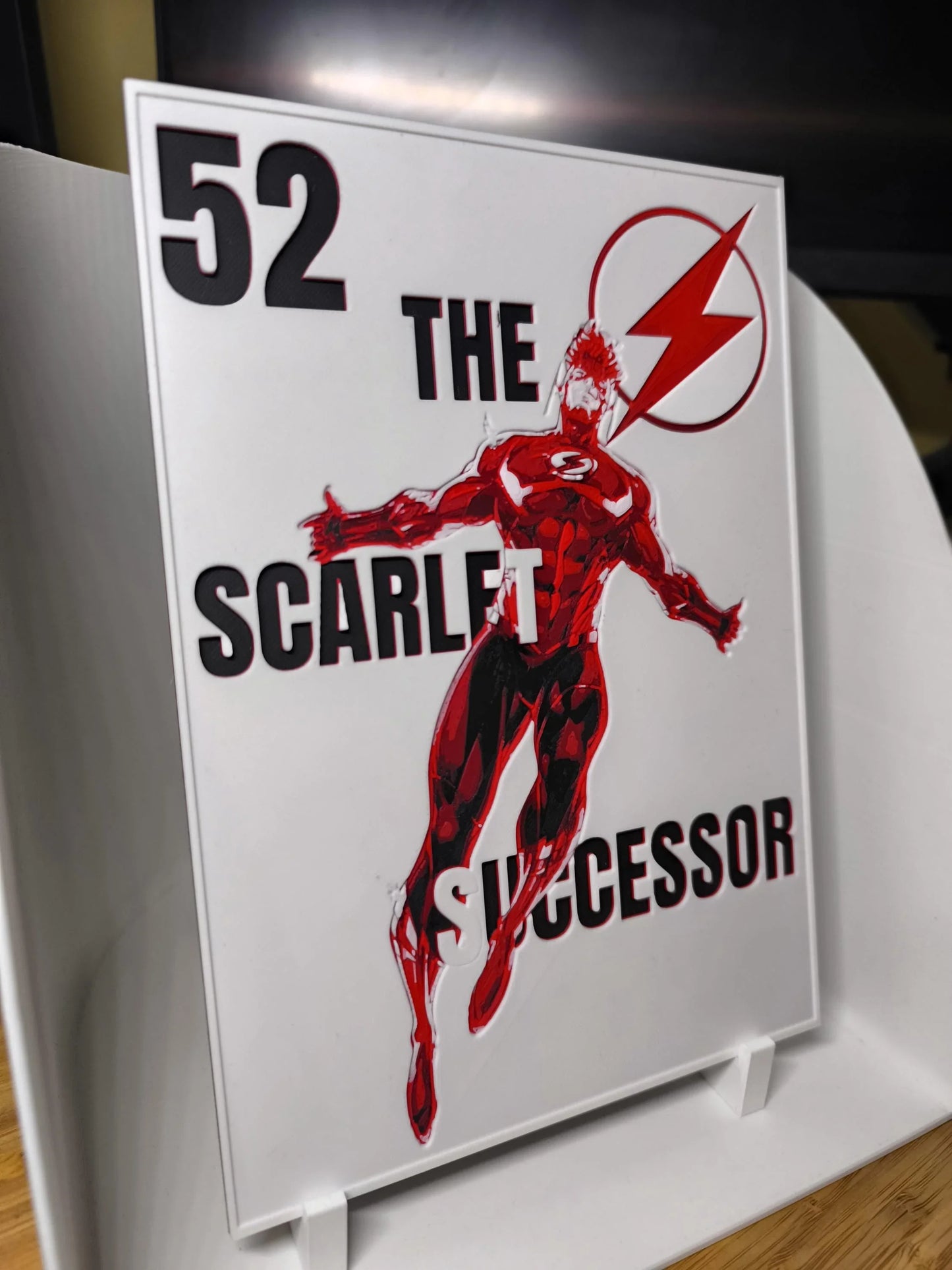 Illustration d'un super-héros rouge sur plaque décorative avec texte The Scarlet Successor et numéro 52