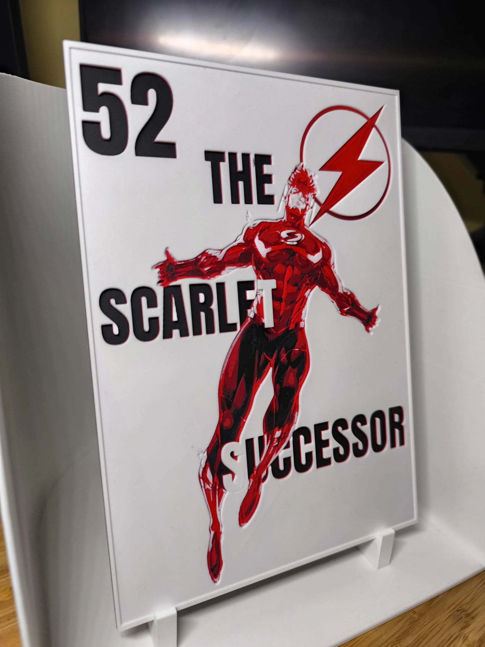 Illustration d'un super-héros rouge sur plaque décorative avec texte The Scarlet Successor et numéro 52