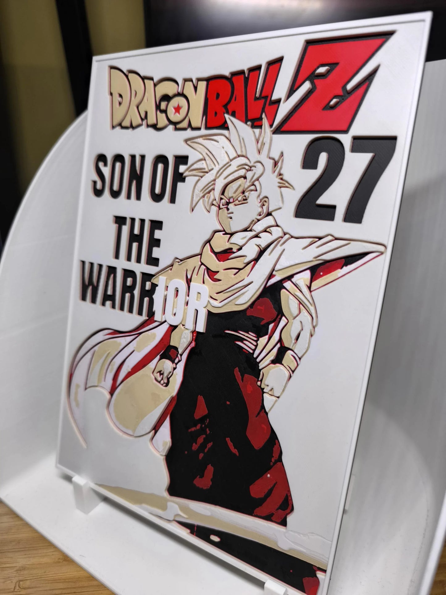 Plaque Dragon Ball Z avec personnage et texte Son of the Warrior 27 sur support blanc