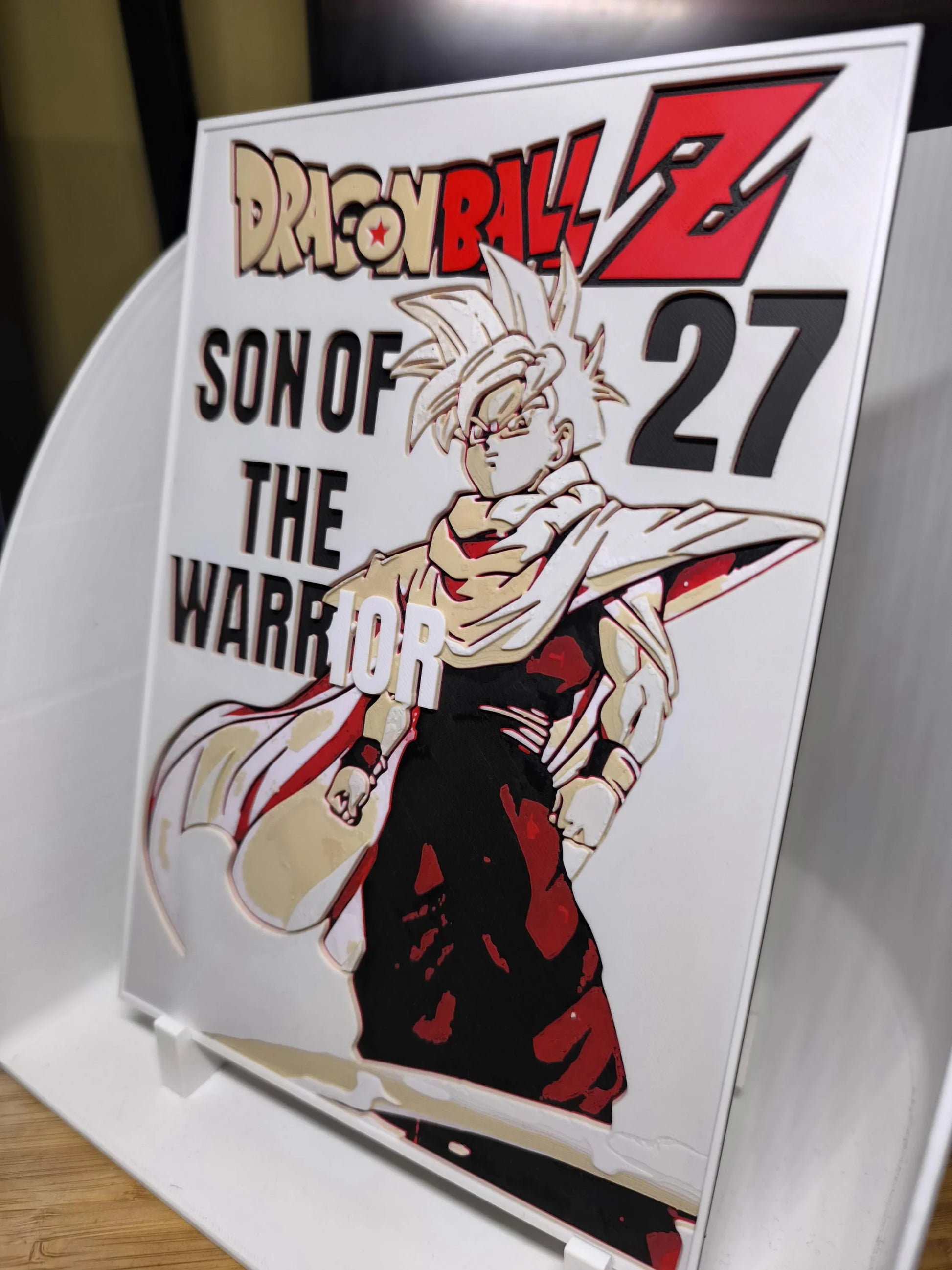 Plaque Dragon Ball Z avec personnage et texte Son of the Warrior 27 sur support blanc