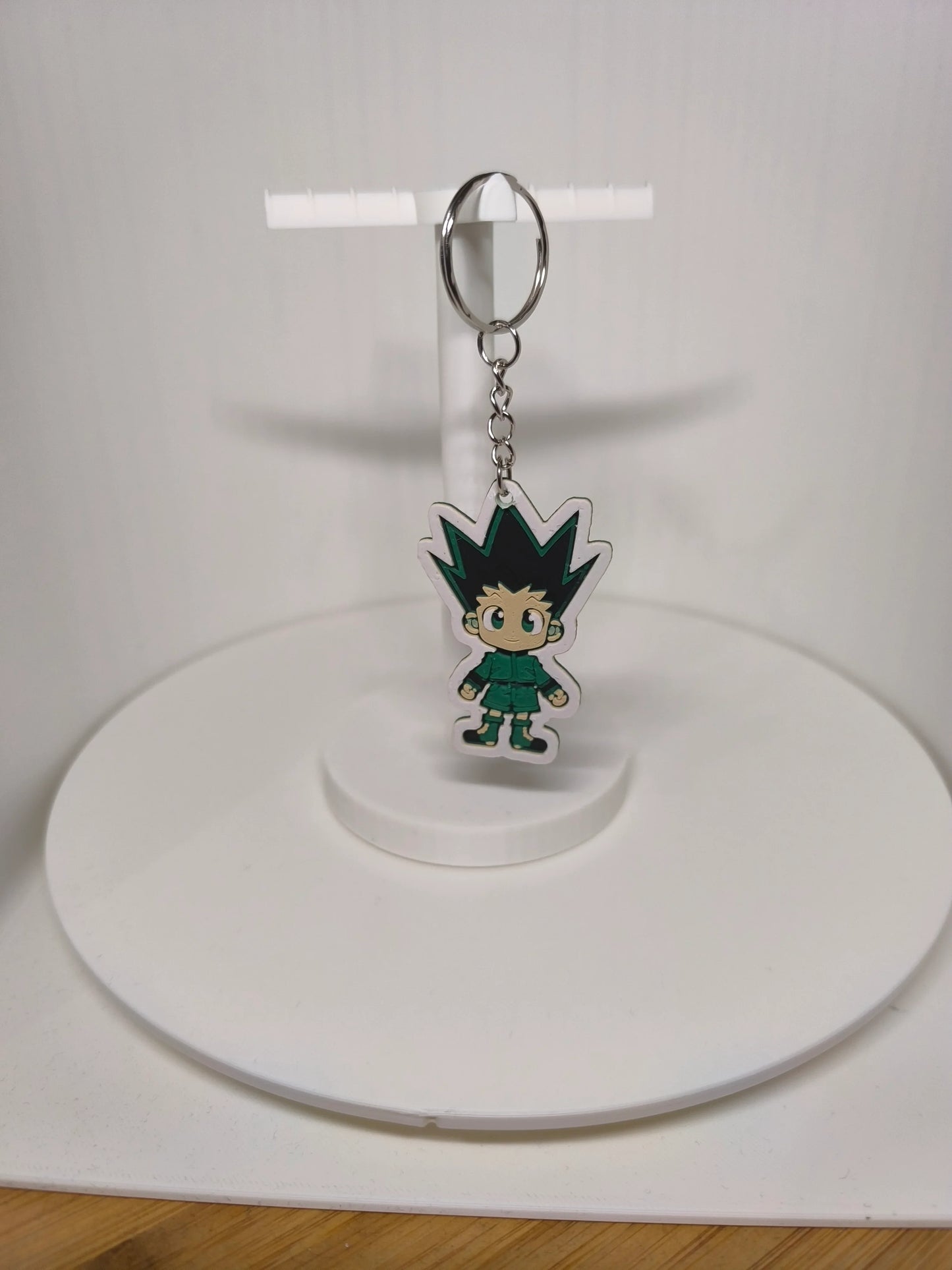 Porte-clés suspendu avec personnage manga aux cheveux noirs pointus sur support blanc