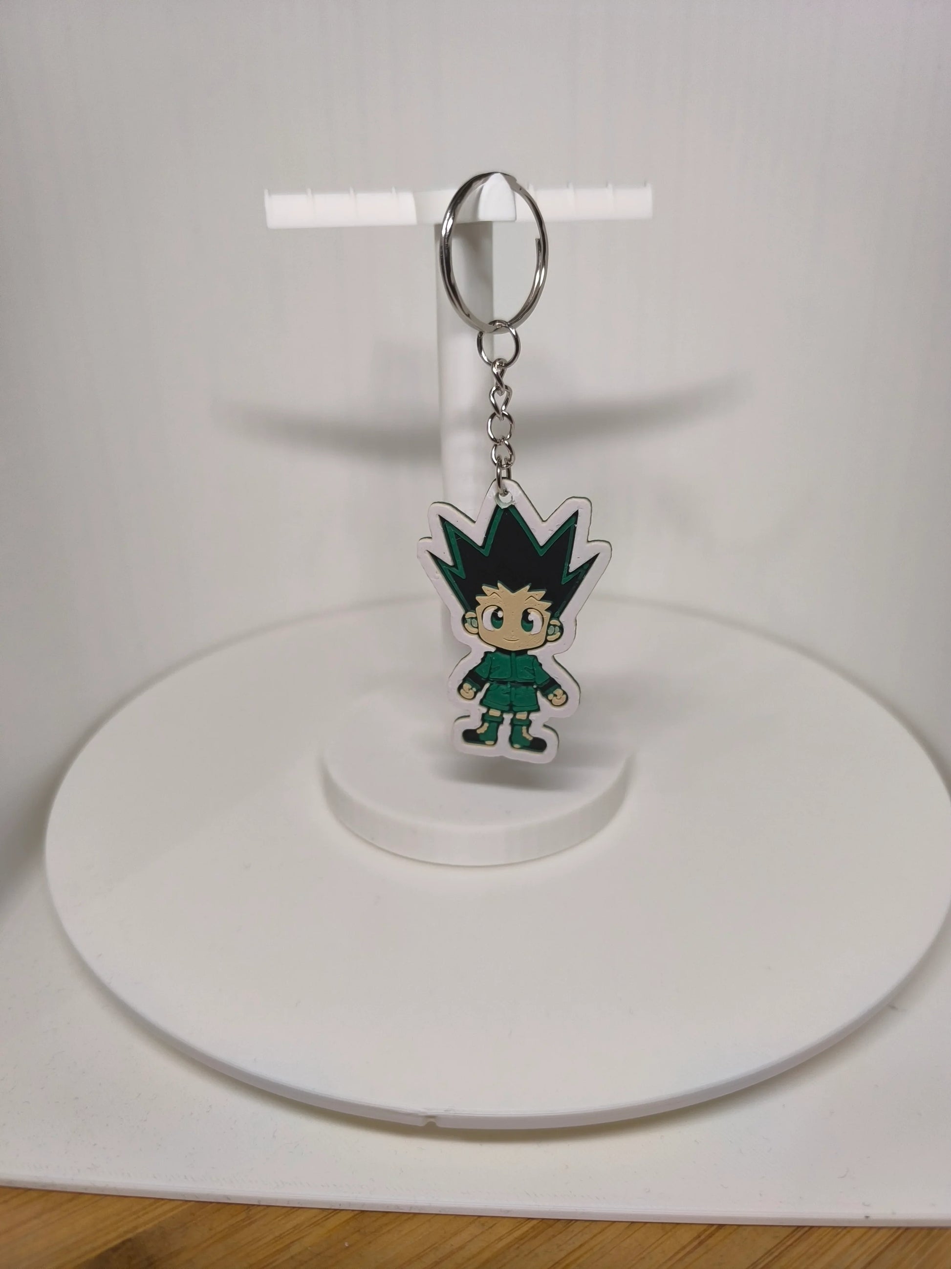 Porte-clés suspendu avec personnage manga aux cheveux noirs pointus sur support blanc