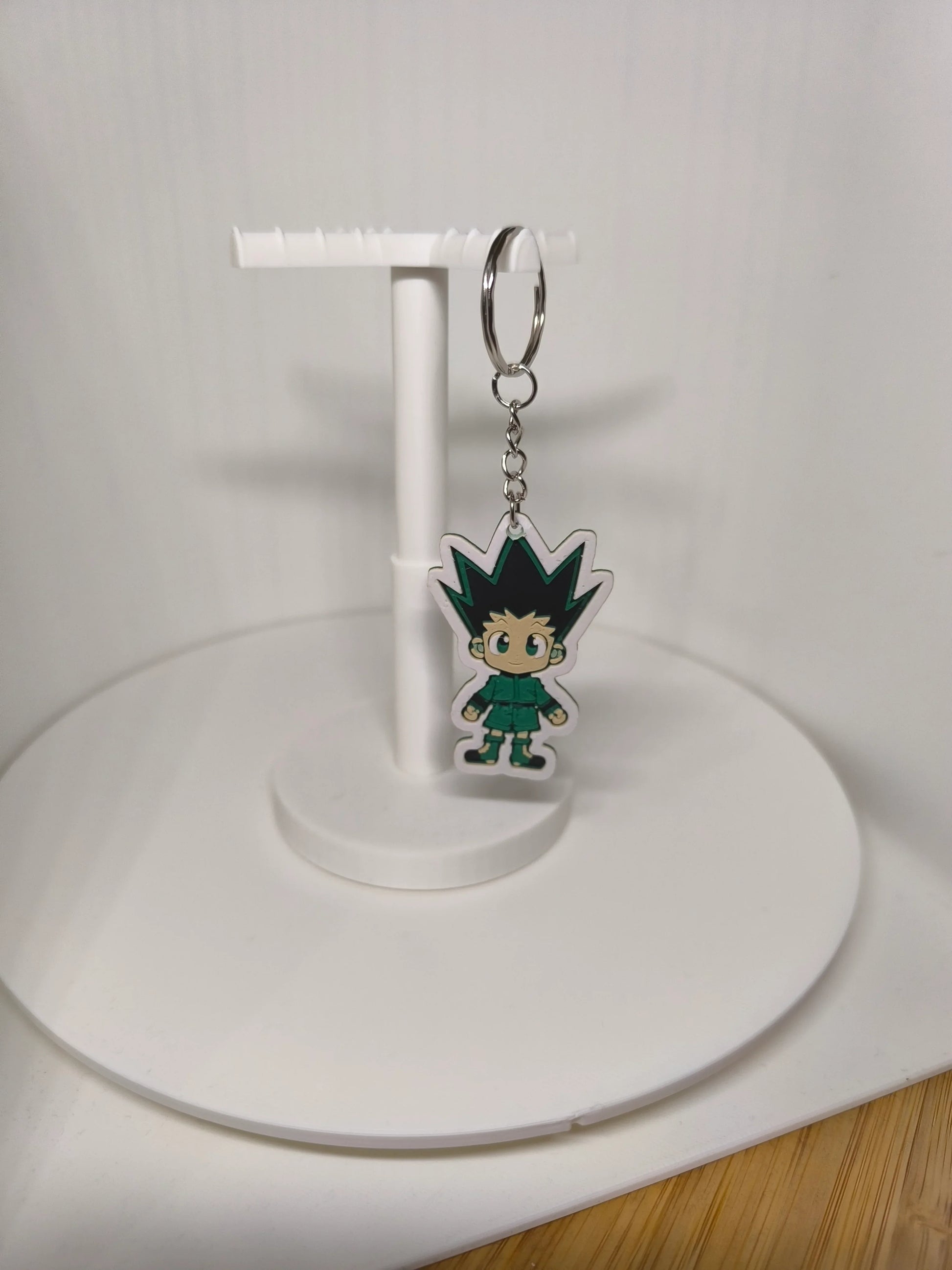 Porte-clés figurine manga chibi garçon cheveux pointus noir et vert sur support blanc