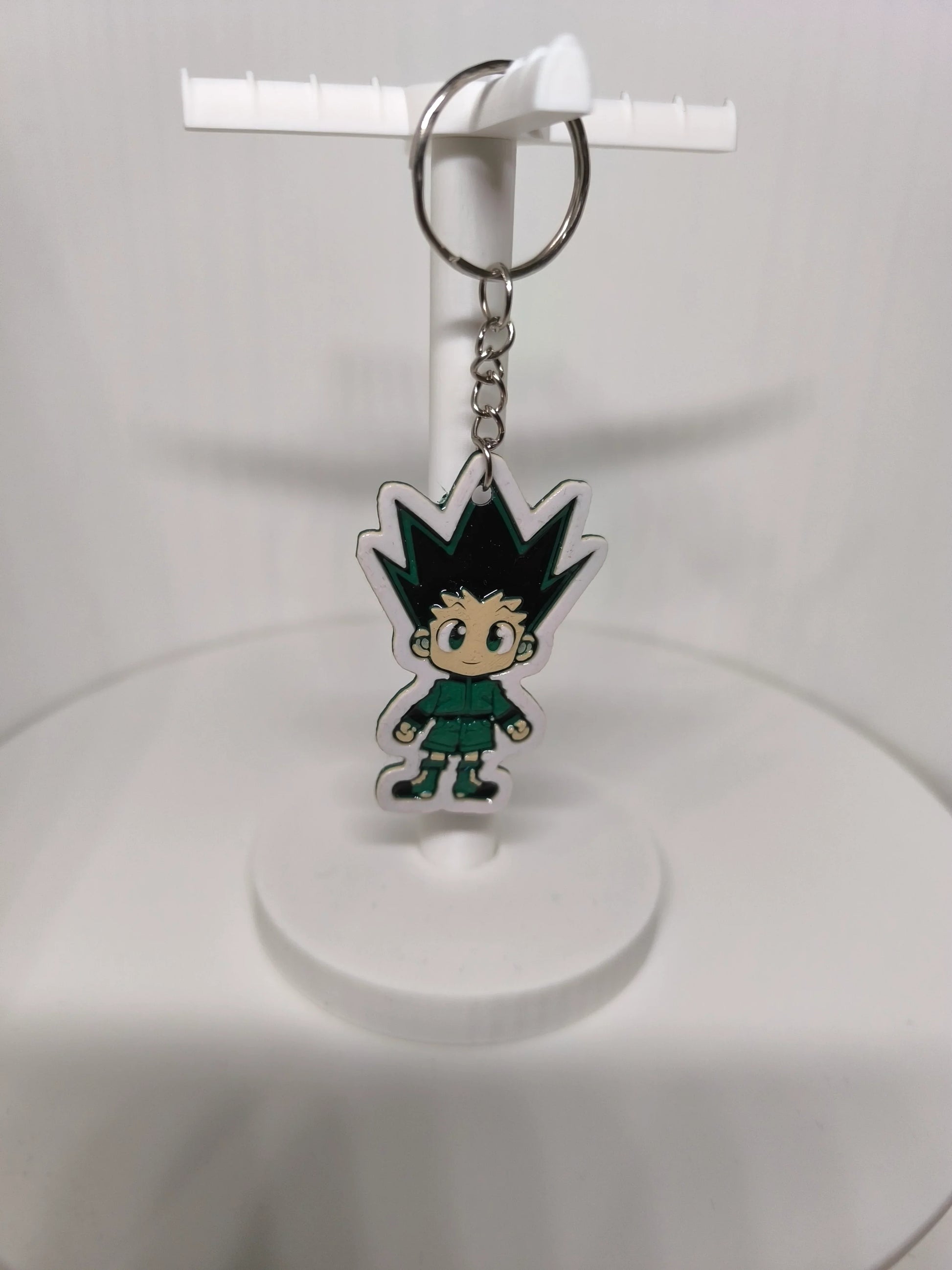 Porte-clés figurine style chibi avec personnage aux cheveux noirs en pointe et tenue verte