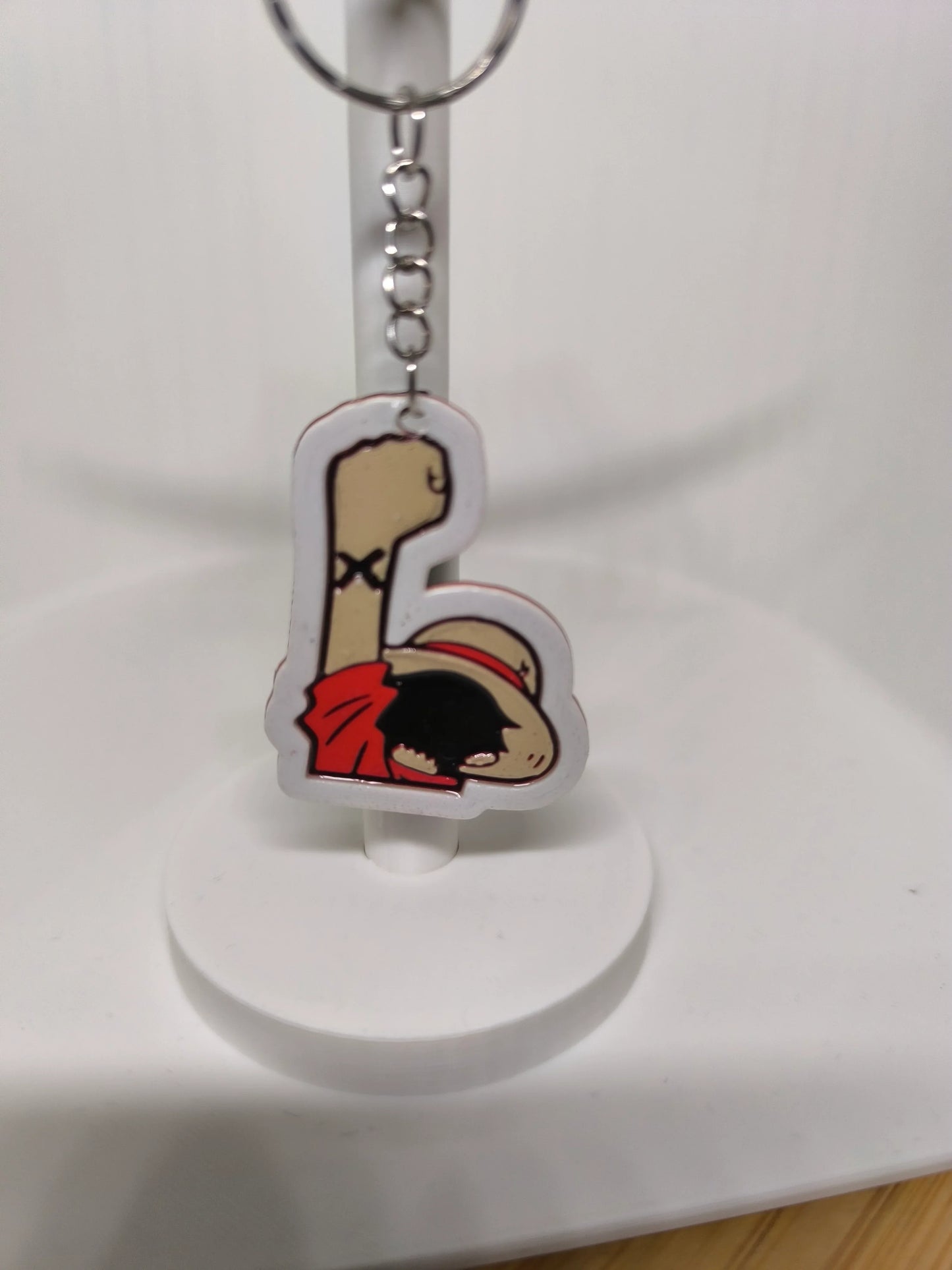 Porte-clés en acrylique avec dessin de poing levé et personnage en chapeau de paille rouge