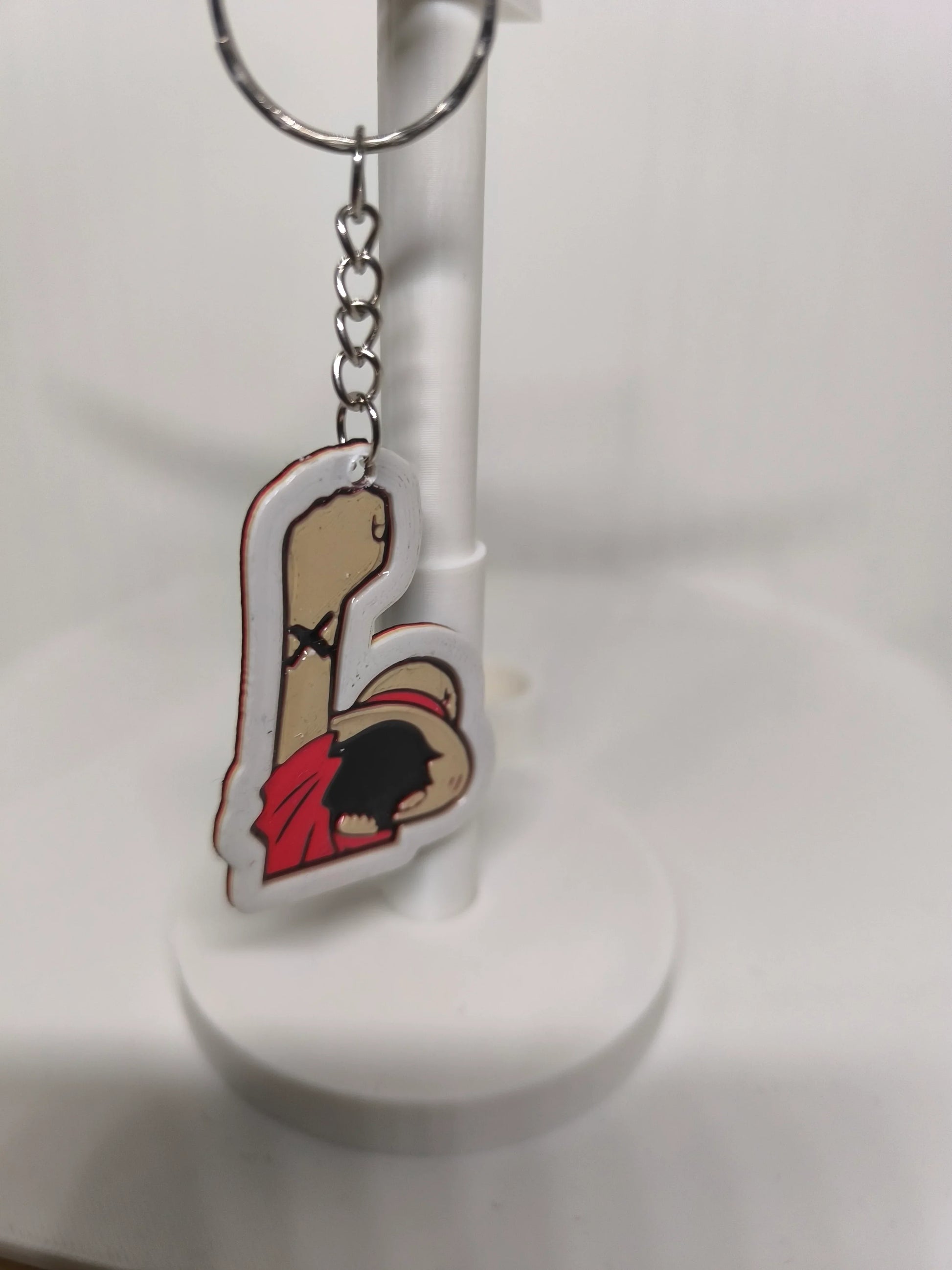 Porte-clés avec illustration couleur d'un personnage en rouge sur support blanc