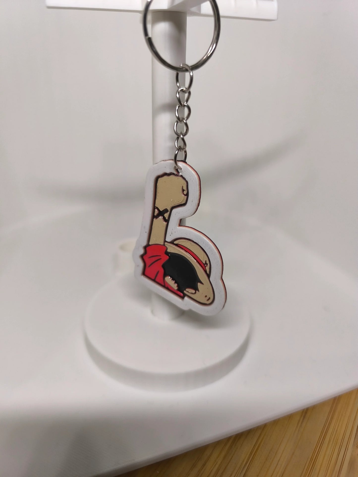 Porte-clés suspendu avec personnage au chapeau de paille rouge et bras levé