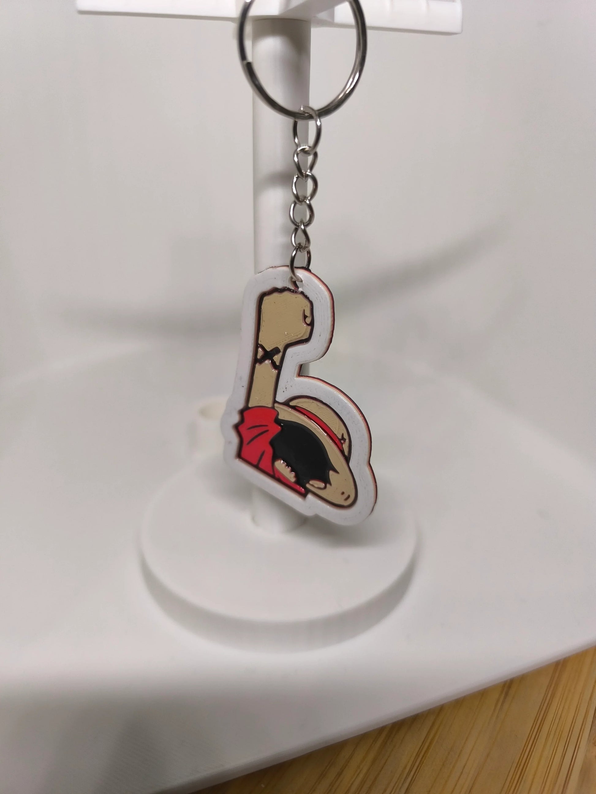 Porte-clés suspendu avec personnage au chapeau de paille rouge et bras levé