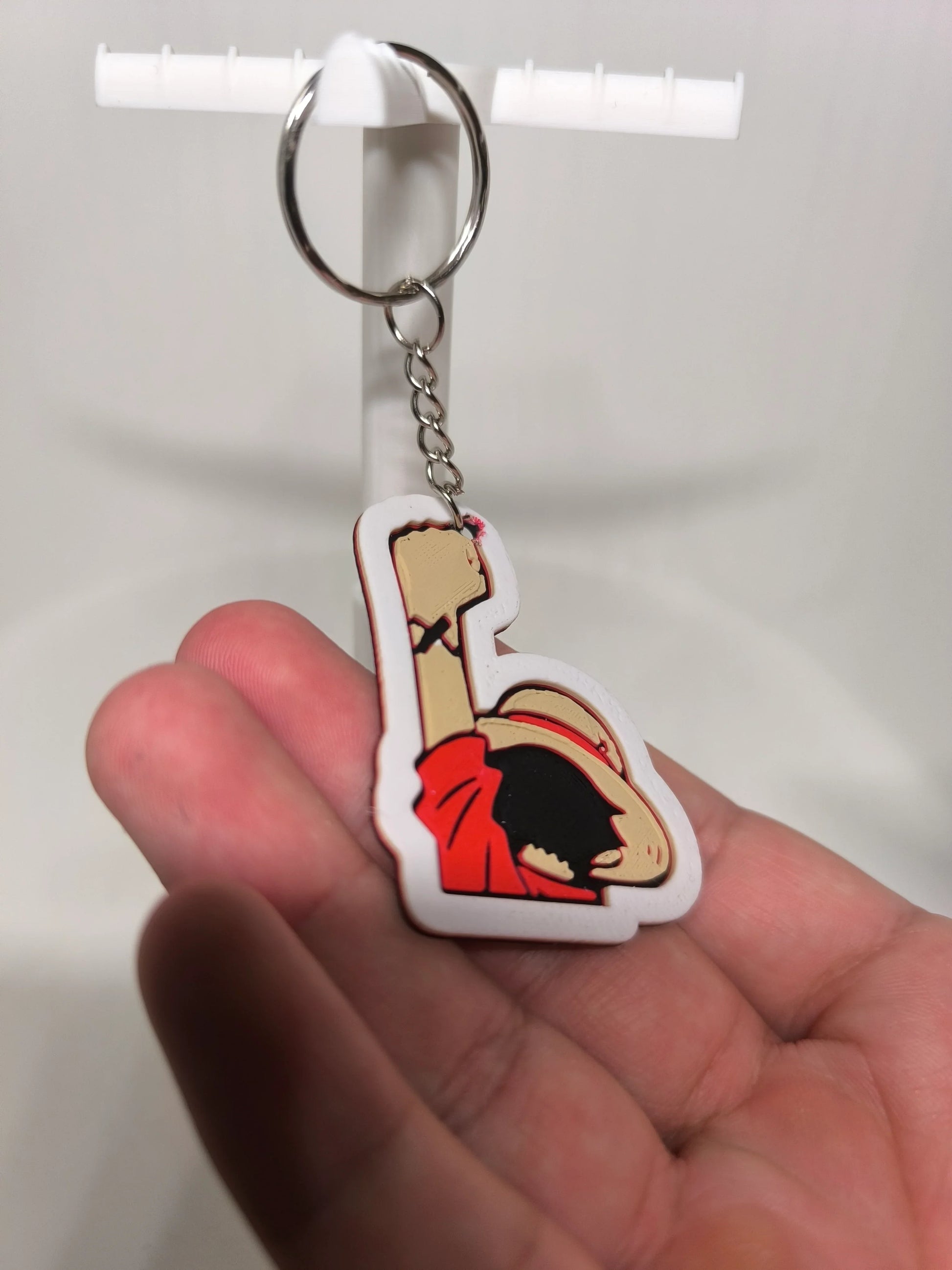 Porte-clés figurine animée main levée chapeau de paille fond blanc main humaine