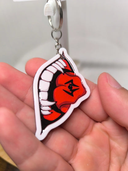 Porte-clés main tenant un pendentif forme bouche avec dents blanches et langue rouge