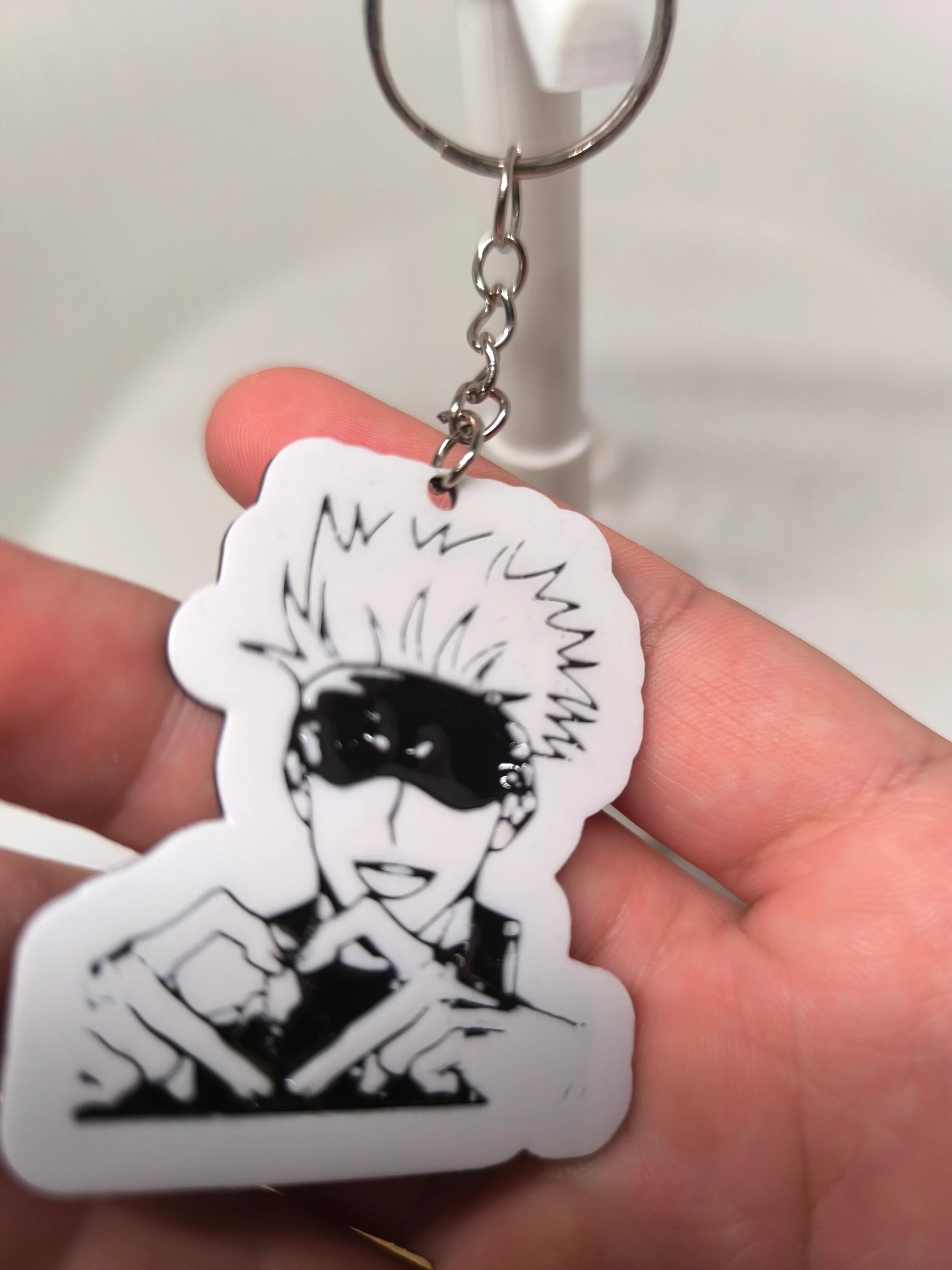 Porte-clés manga en plastique blanc avec personnage aux cheveux ébouriffés et lunettes noires