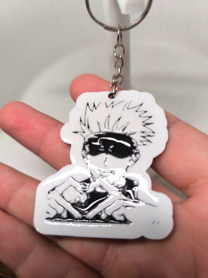 Porte-clés en plastique avec dessin noir et blanc d'un personnage animé aux cheveux ébouriffés et lunettes de soleil