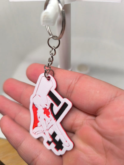 Porte-clés fantaisie en plastique représentant une femme assise, tenu à la main sur fond clair