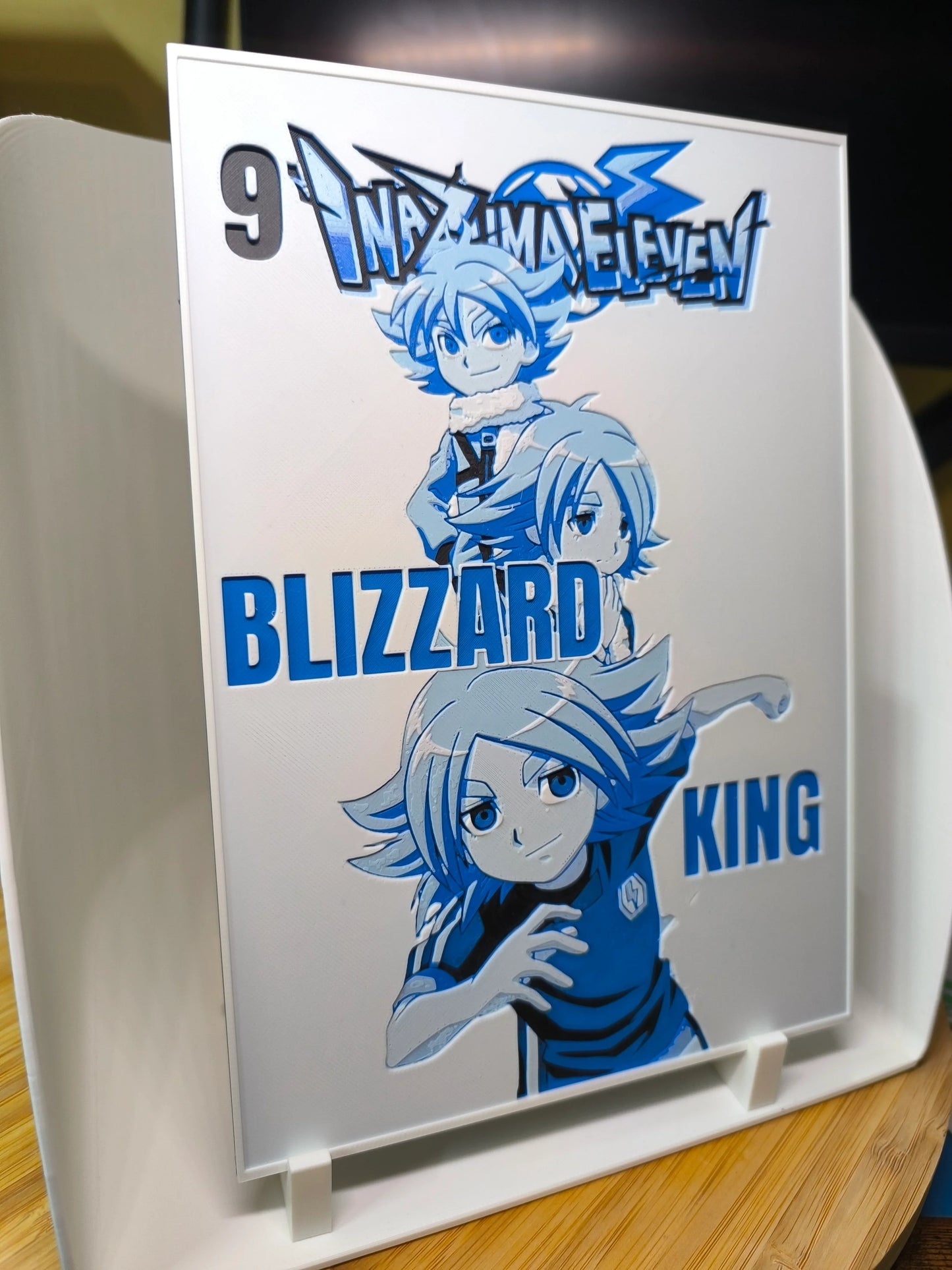 Illustration Inazuma Eleven avec personnages Blizzard King en bleu sur plaque blanche