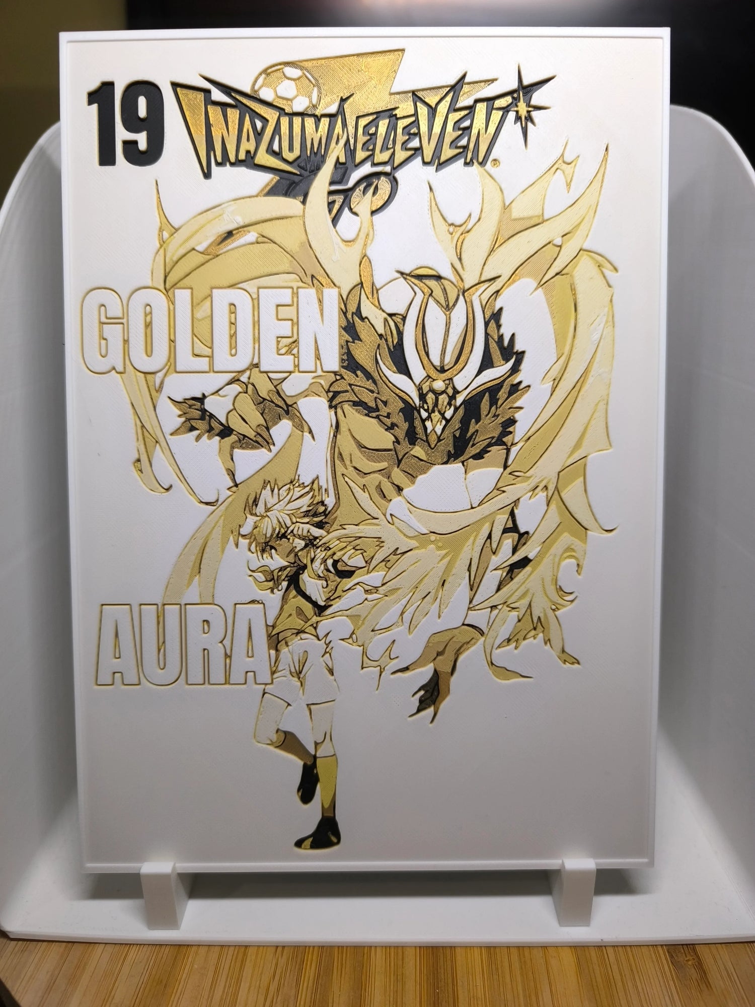 Illustration dorée Inazuma Eleven avec personnage et créature mystique sur fond blanc