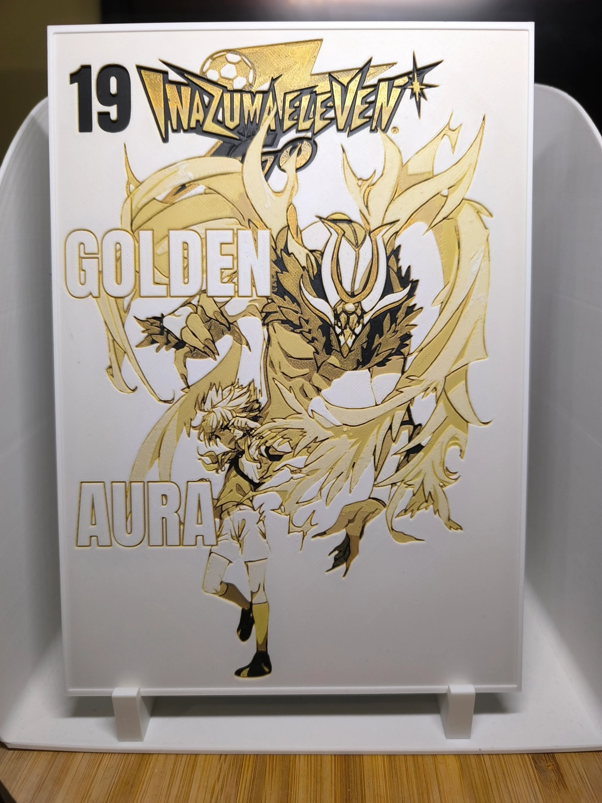 Illustration dorée Inazuma Eleven avec personnage et créature mystique sur fond blanc