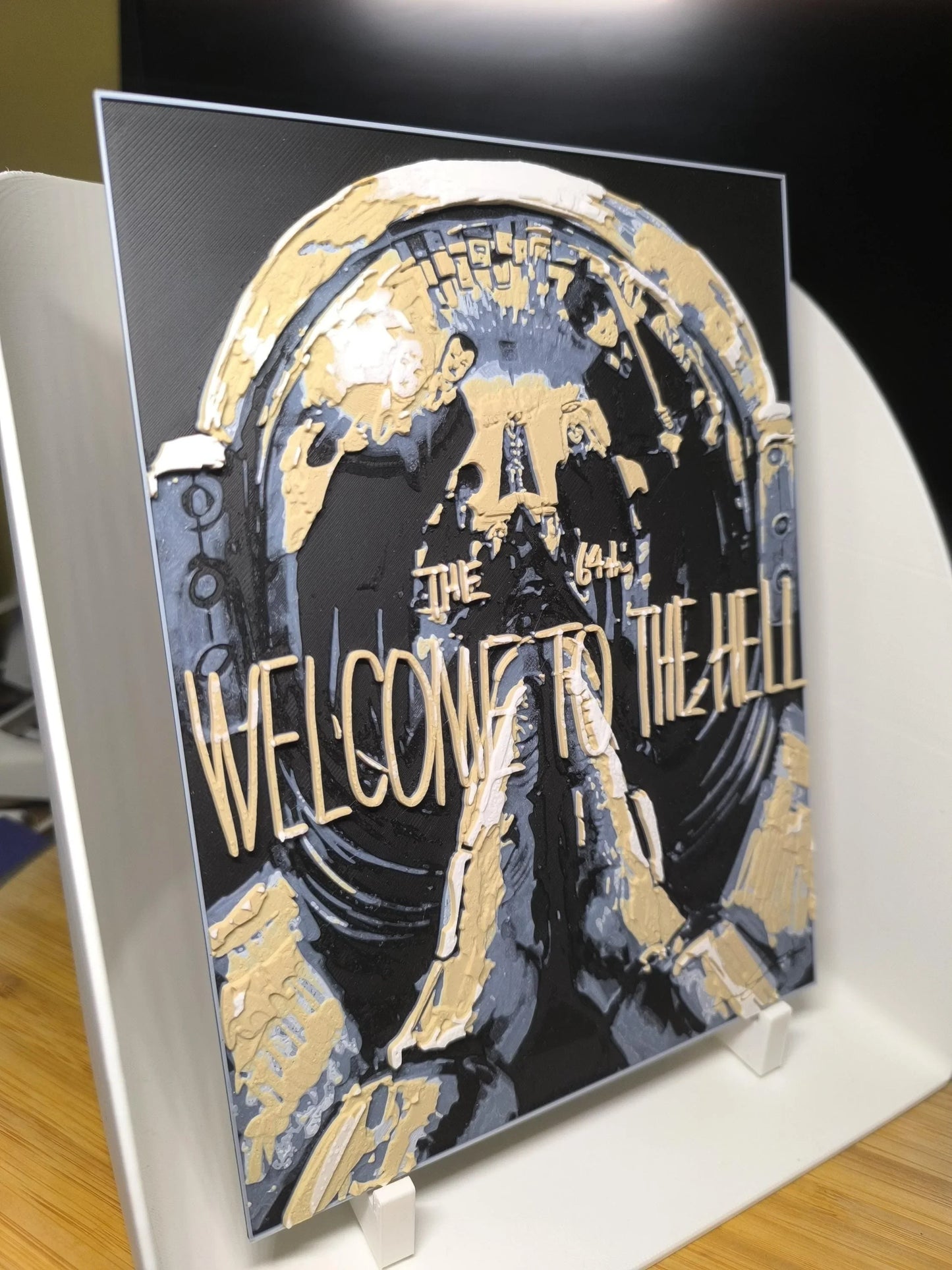 Tableau artistique texturé avec l'inscription dorée 'WELCOME TO THE HELL' sur fond sombre en relief