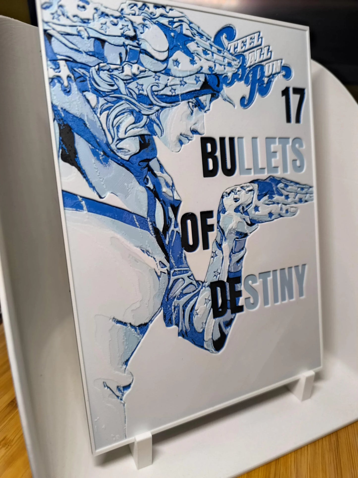 Tableau en relief Bleu et blanc figurant un personnage stylisé avec texte bullets of destiny sur plaque montée