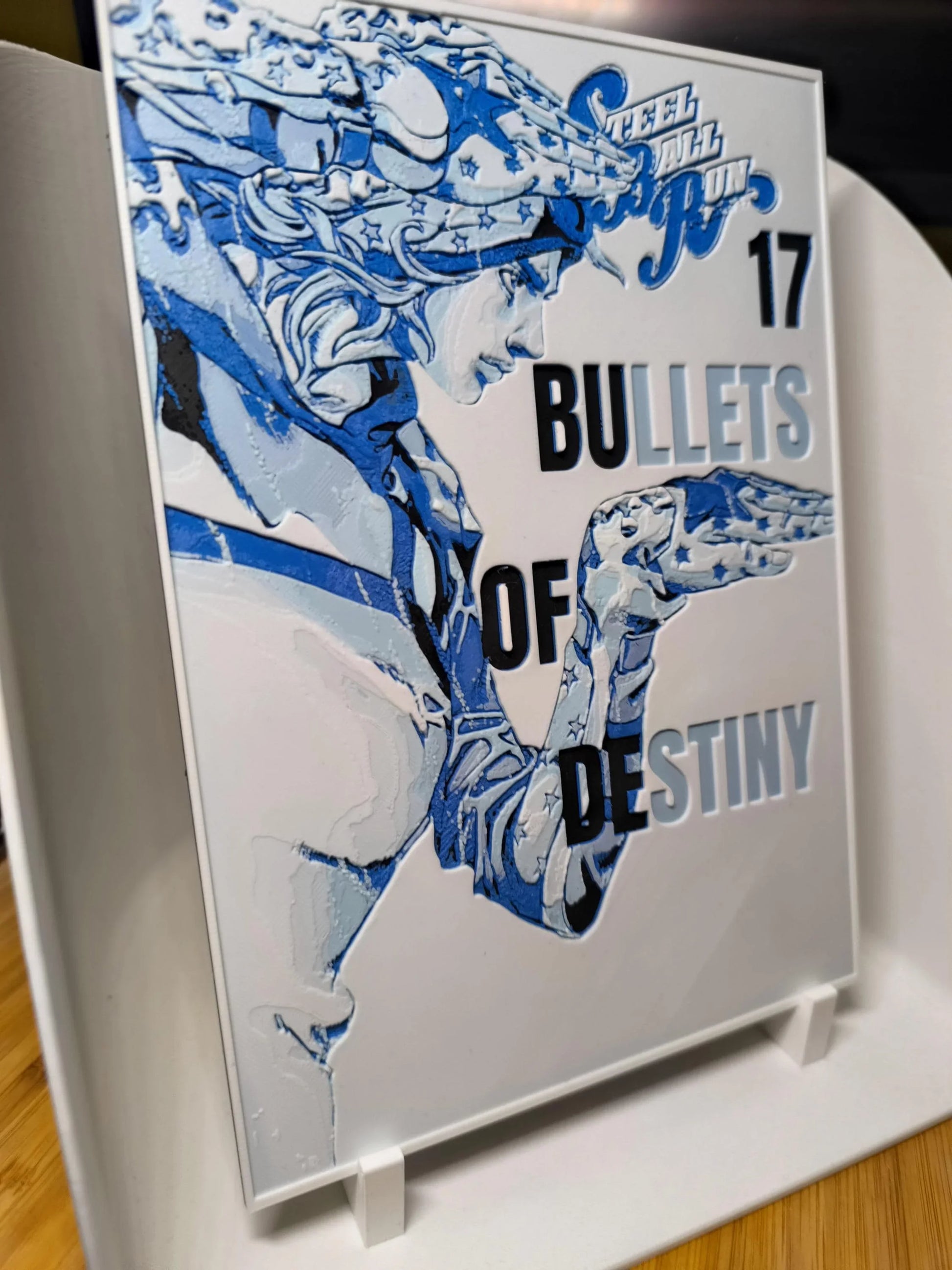 Tableau en relief Bleu et blanc figurant un personnage stylisé avec texte bullets of destiny sur plaque montée