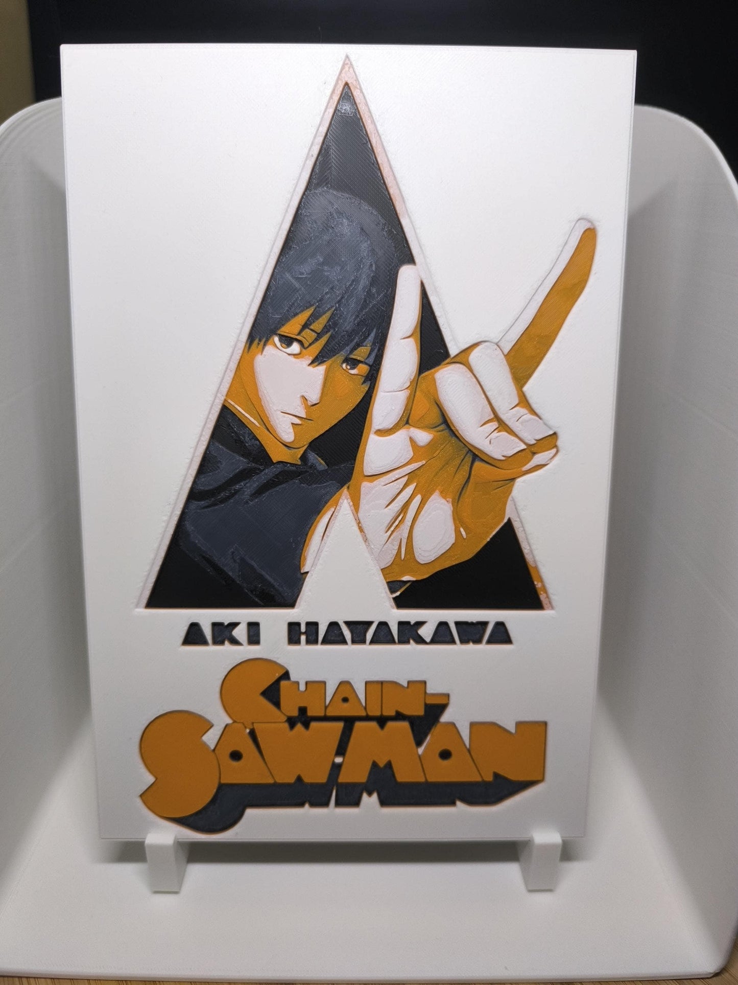 Illustration d'Aki Hayakawa de l'anime Chain Saw Man avec logo stylisé sur support blanc
